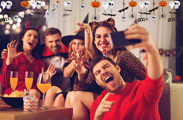 Image showing happy friends in halloween costumes taking selfie