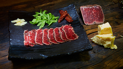 Image showing Barbecue wagyu roast beef sliced as top view on a metal tray with copy space right