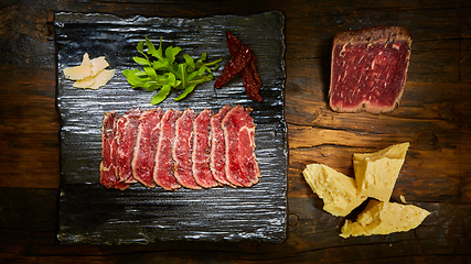 Image showing Barbecue wagyu roast beef sliced as top view on a metal tray with copy space right