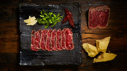 Image showing Barbecue wagyu roast beef sliced as top view on a metal tray with copy space right