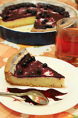 Image showing Piece of pie with bilberry on the plate and cup of tea