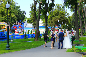 Image showing married couple with friends walk in park with big trees