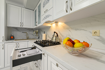 Image showing Open drawers with kitchenware at modern white kitchen