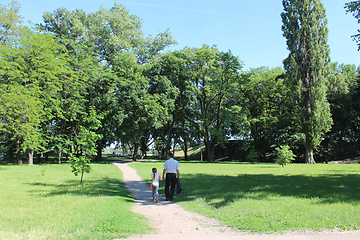 Image showing father with his daughter have a rest in park with big trees