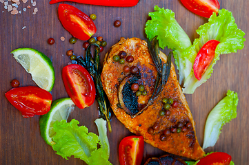 Image showing wood fired hoven cooked chicken breast on wood board