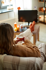 Image showing woman watches tv and drinks cocoa on halloween