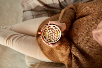 Image showing woman holding mug of hot chocolate and marshmallow