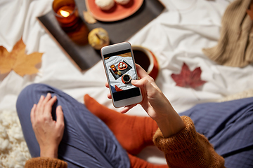 Image showing woman with smartphone taking picture of autumn set