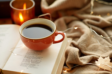 Image showing cup of coffee, book on window sill in autumn