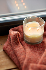 Image showing woolen sweater and candle burning on window sill