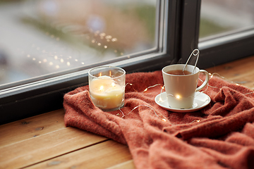 Image showing cup of tea and candle on window sill