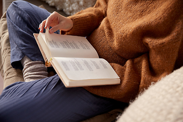 Image showing woman in warm sweater reading book at home