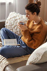 Image showing woman drinking coffee and reading book at home