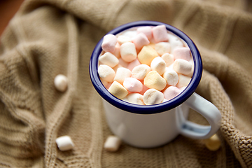 Image showing camp mug full of marshmallow on knitted blanket