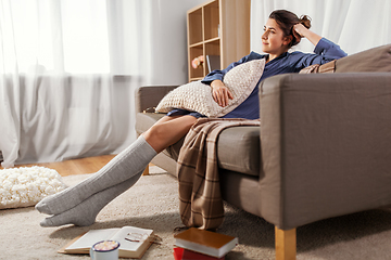 Image showing woman with pillow and books on floor at home