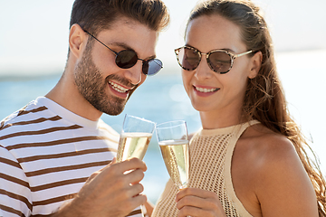 Image showing happy couple drinking champagne on summer beach