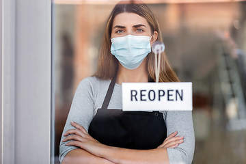 Image showing woman in mask with reopen banner on door glass