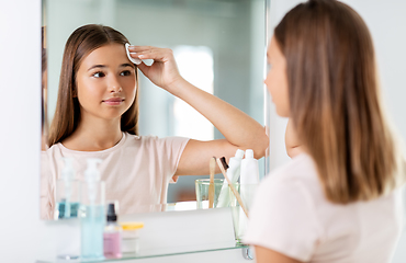 Image showing teenage girl cleaning face skin with cotton disc