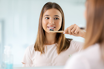 Image showing teenage girl with toothbrush brushing teeth