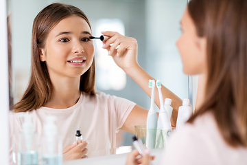 Image showing teenage girl applying mascara at bathroom