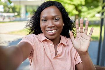 Image showing happy african american woman taking selfie in city