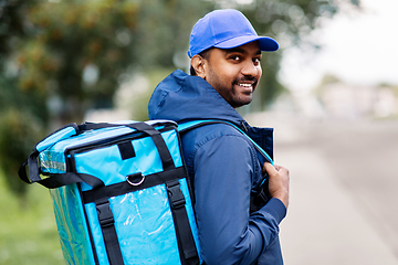 Image showing happy smiling indian delivery man with bag in city