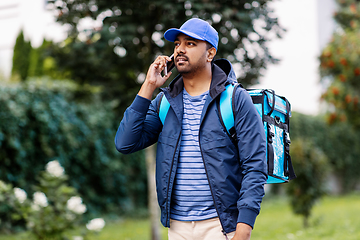 Image showing indian delivery man with bag calling on smartphone