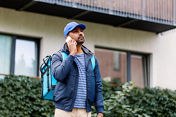 Image showing indian delivery man with bag calling on smartphone