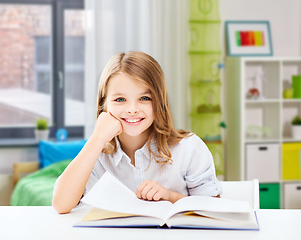 Image showing happy smiling student girl reading book at home