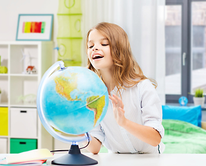 Image showing smiling student girl with globe at home