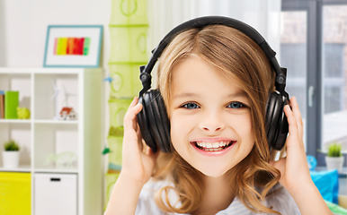 Image showing happy smiling girl with headphones at home