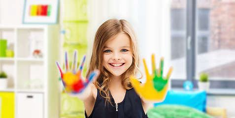 Image showing smiling girl showing painted hands at home