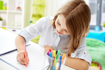 Image showing girl with felt-tip pen drawing picture in notebook