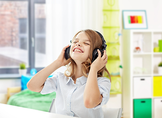 Image showing happy smiling girl with headphones at home