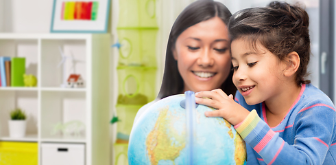 Image showing mother and daughter with globe at home