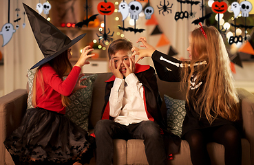 Image showing kids in halloween costumes playing at home