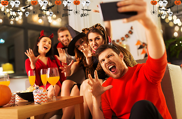 Image showing happy friends in halloween costumes taking selfie