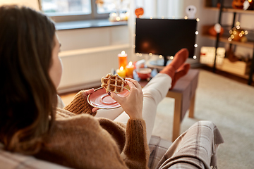 Image showing woman watching tv and eating waffle on halloween