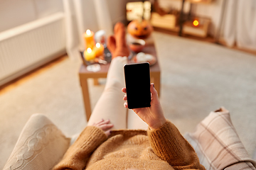 Image showing woman using smartphone at home on halloween