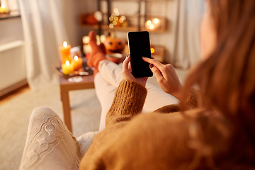 Image showing woman using smartphone at home on halloween