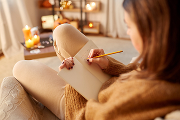 Image showing woman writing to diary at home on halloween