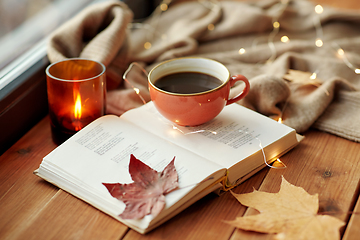 Image showing cup of coffee, book on window sill in autumn