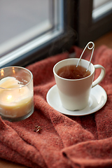 Image showing cup of tea and candle on window sill