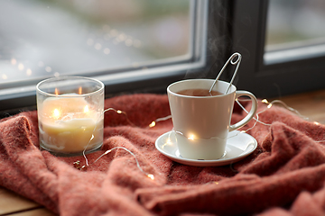 Image showing cup of tea and candle on window sill