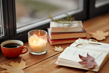 Image showing book, coffee and candle on window sill in autumn