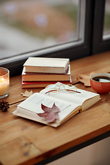 Image showing book, coffee and candle on window sill in autumn