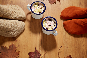 Image showing couple of feet in socks, coffee and autumn leaves