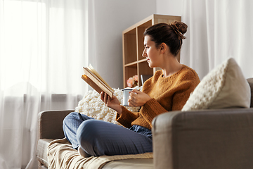 Image showing woman drinking coffee and reading book at home