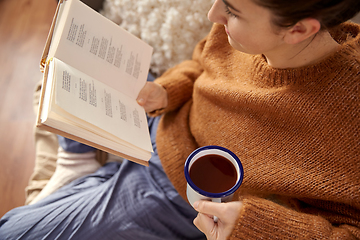 Image showing woman reading book and drinking coffee at home