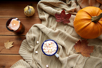 Image showing cup of marshmallow, candle and pumpkin on window